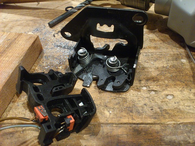 Vnutro zamku. Vlavo spinac pre kontrolku odomknutia dveri. Vpravo spinac pre svetlo v kufri.